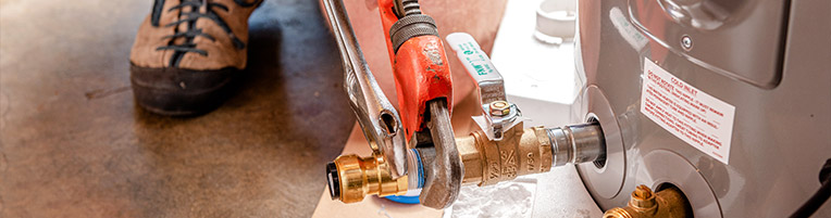 Person using wrenches to tighten hybrid water heater valve
