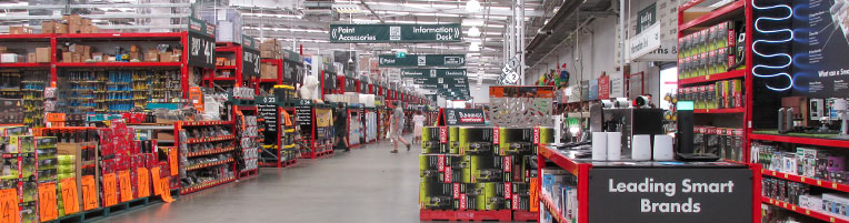 Interior of a hardware store with many rows of aisles and products on the shelves